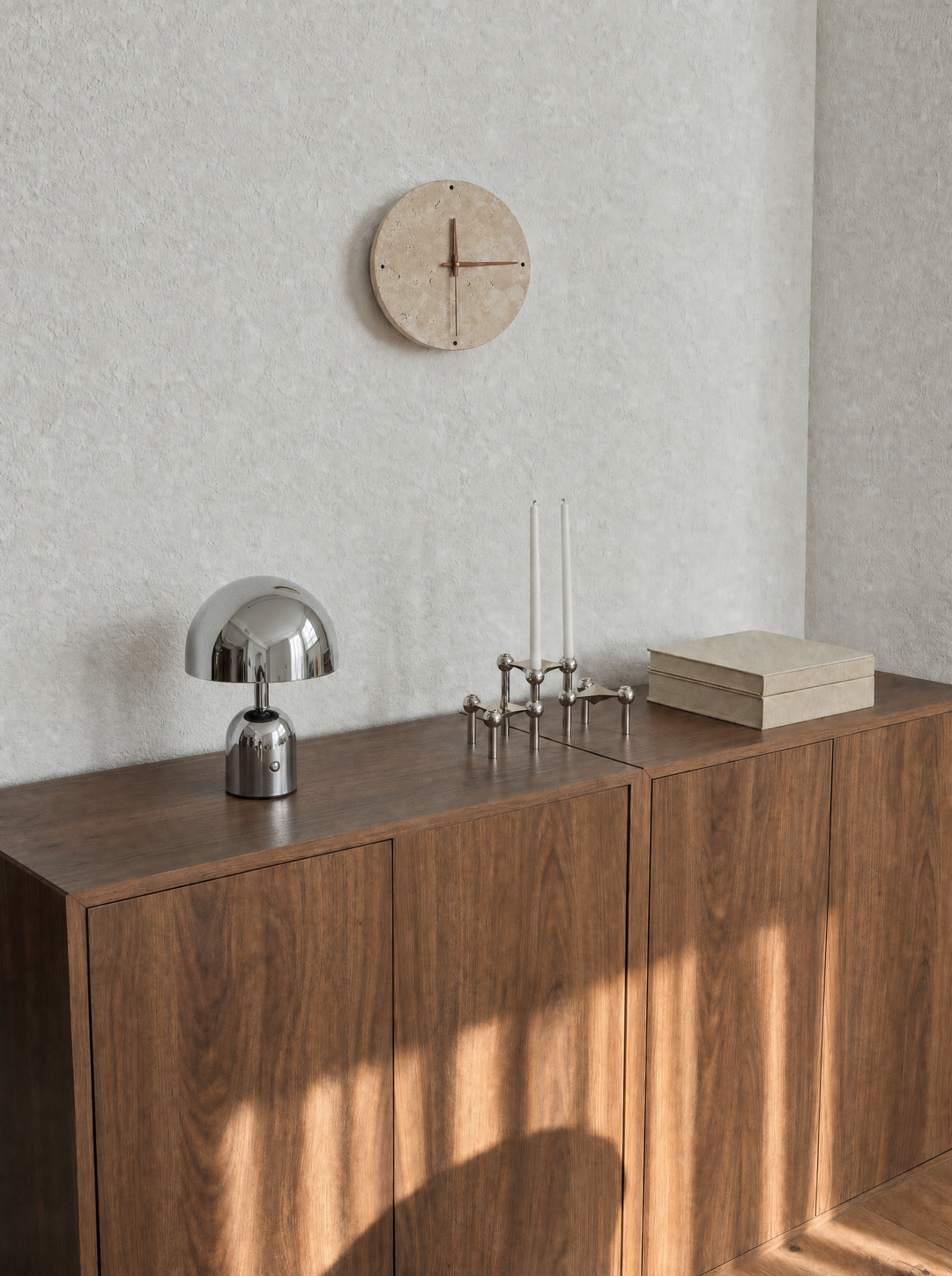 Adagio wall clock on a bare wall in daylight, Vespers lamp nearby