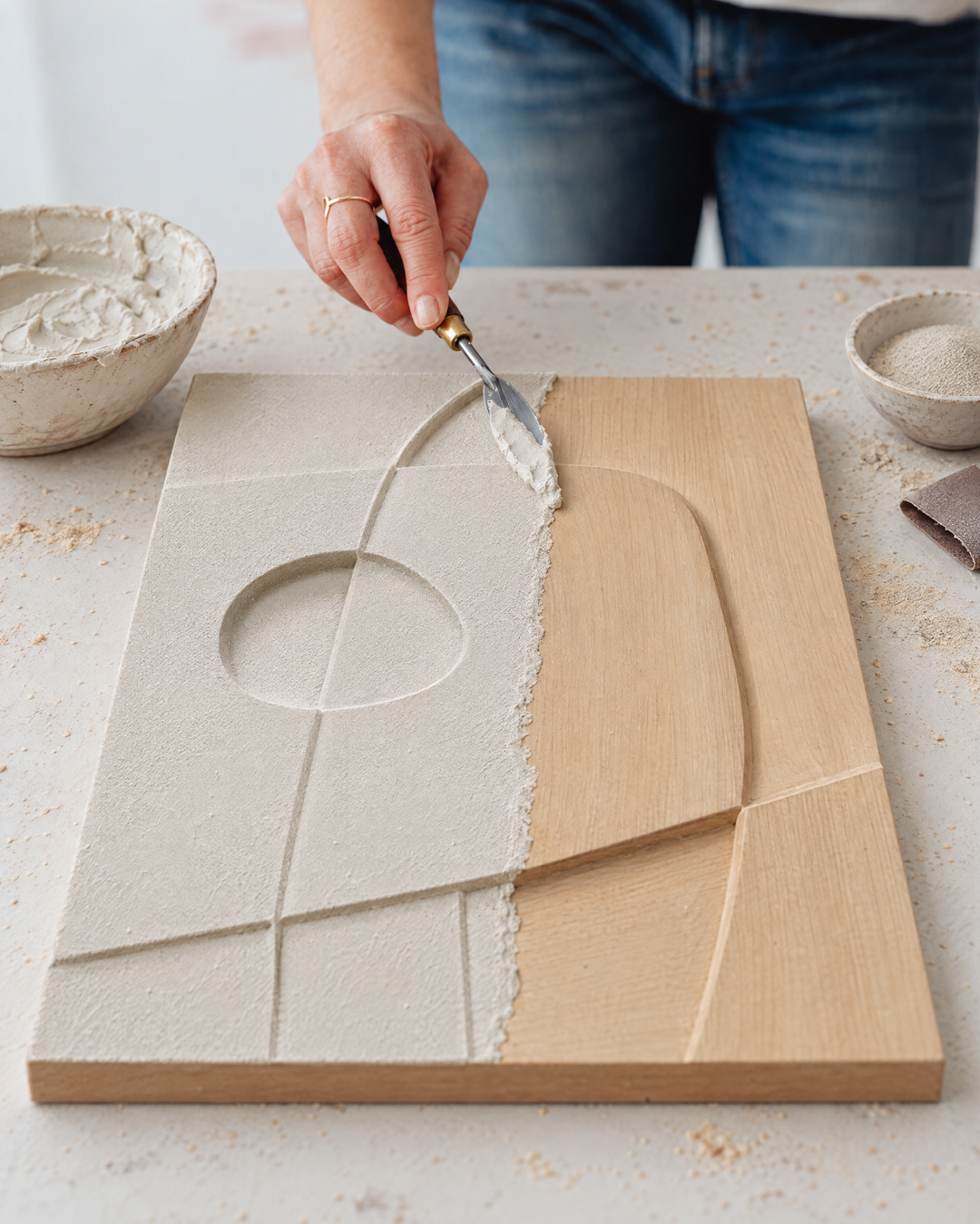 An artisan smoothing the curved forms of Curva by hand