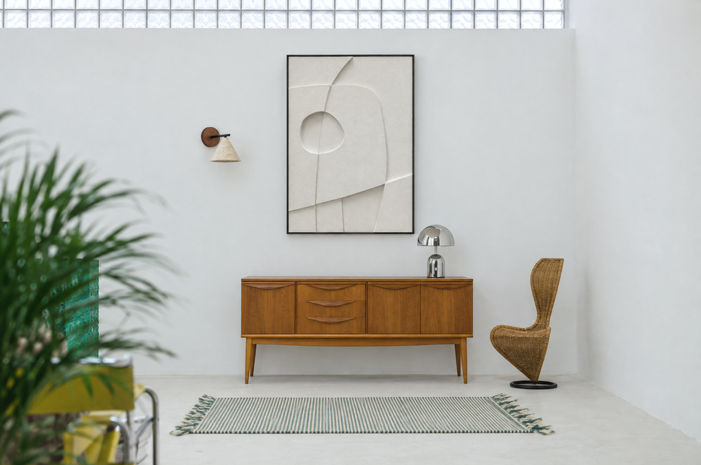 Curva Orma above a wooden sideboard in a bright white room