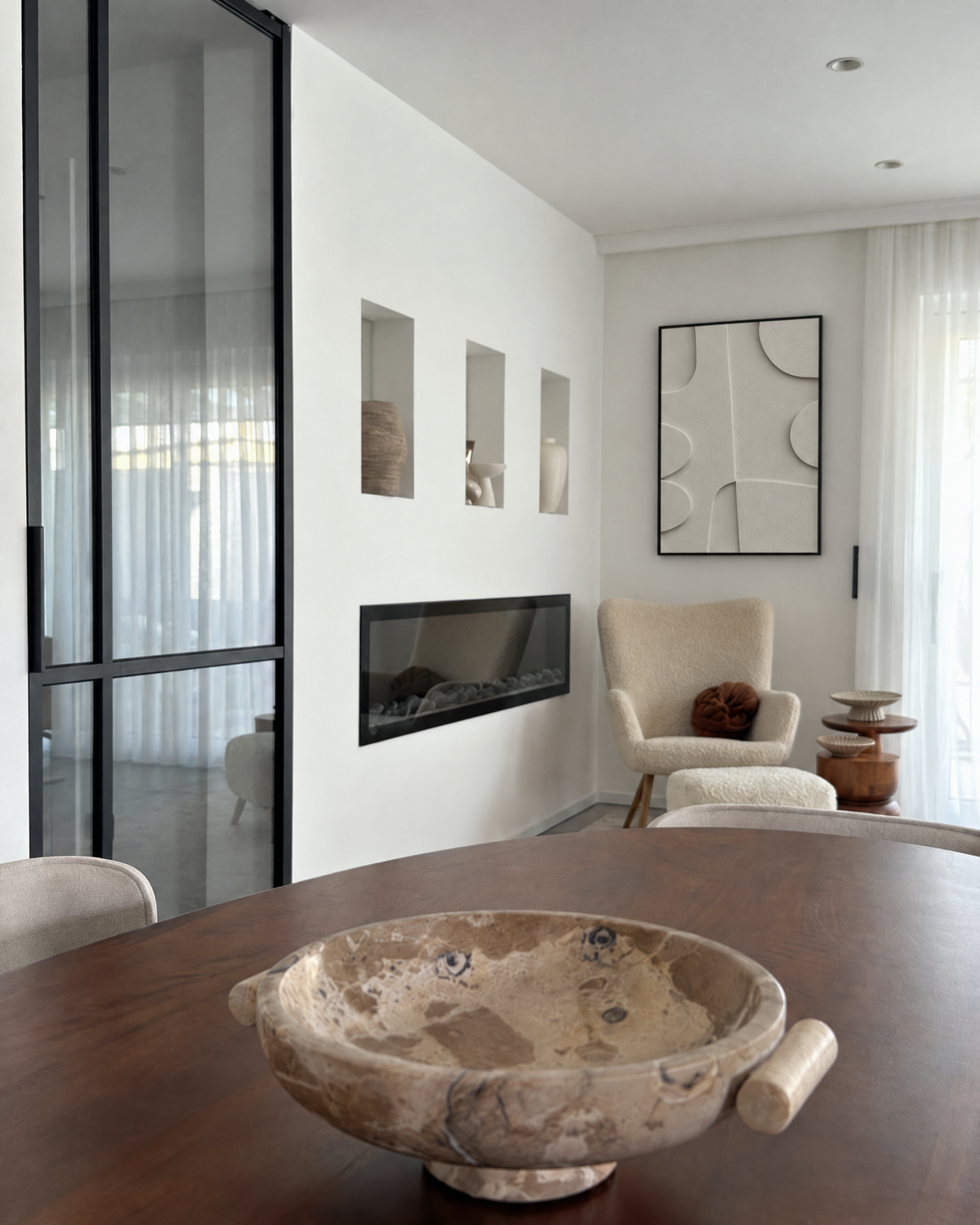 Curva Arco on a white wall beside a long fireplace in a living room