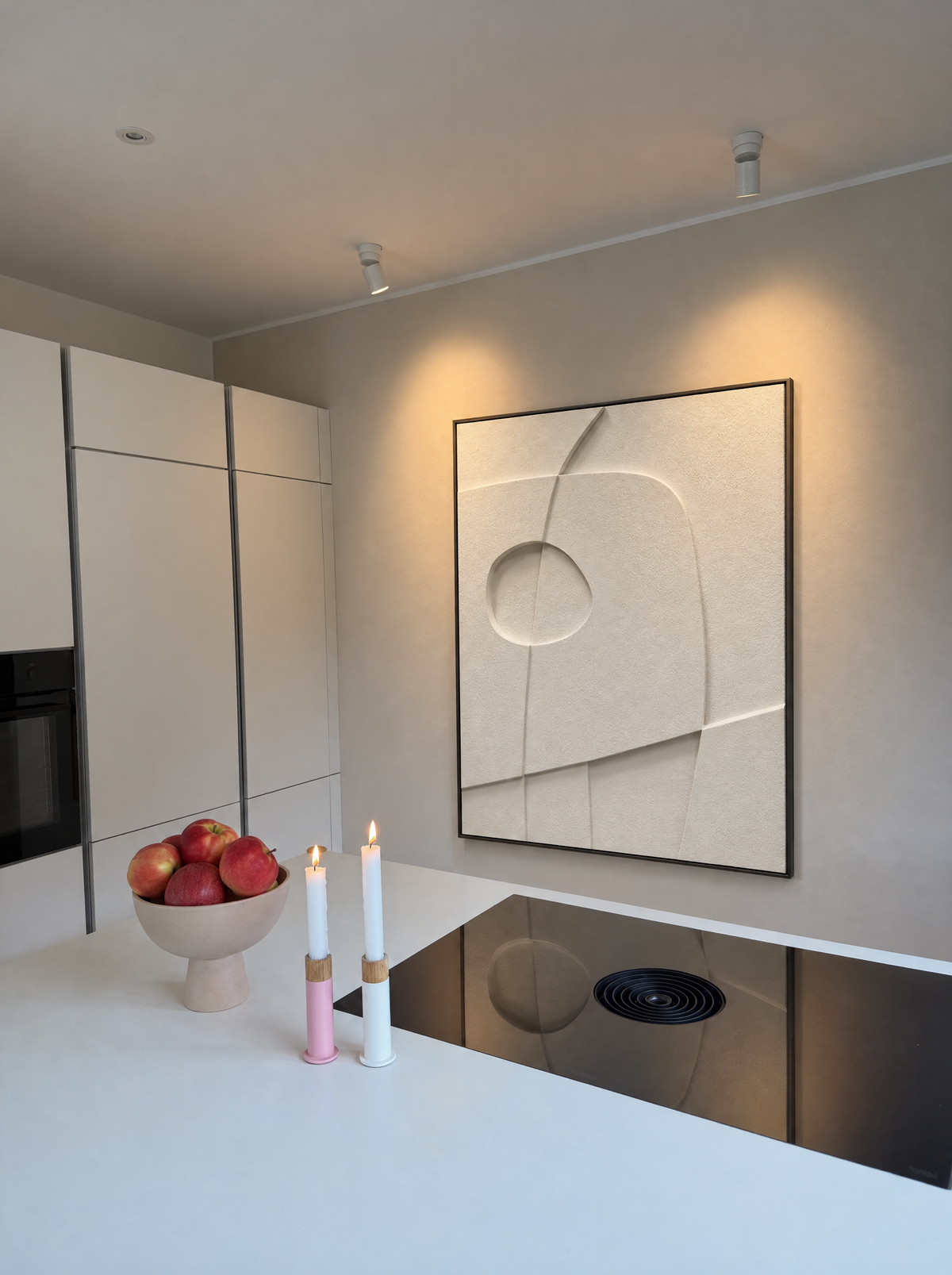 Curva Orma on a kitchen wall above a white counter and a cooktop