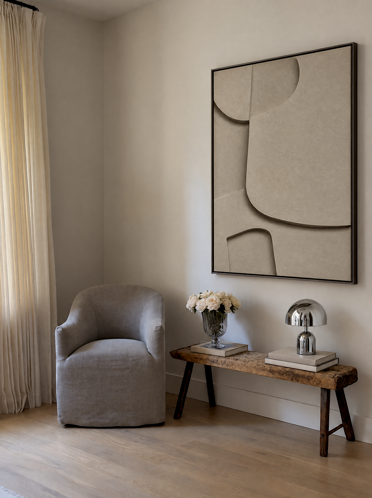 Curva Sasso in a corner above a gray armchair and a rustic wooden bench