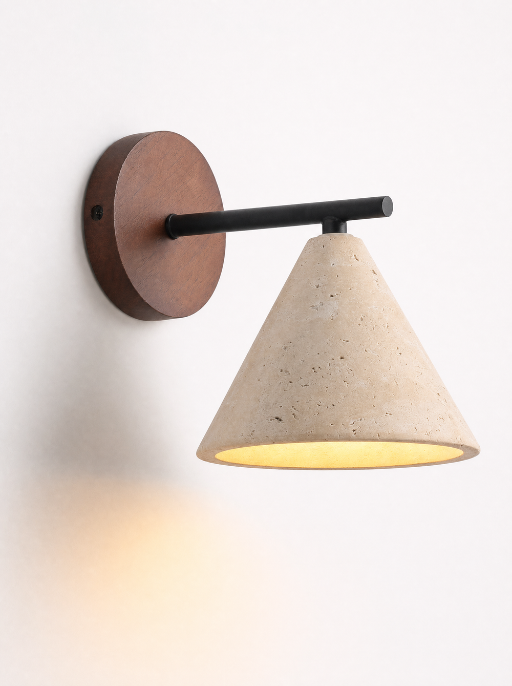 Fonte wall lamp lit, warm light falling below the travertine shade
