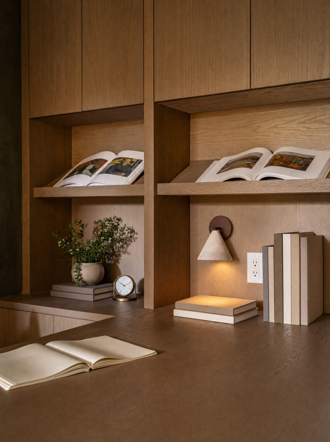 A hand touching the travertine face of the Fonte wall lamp