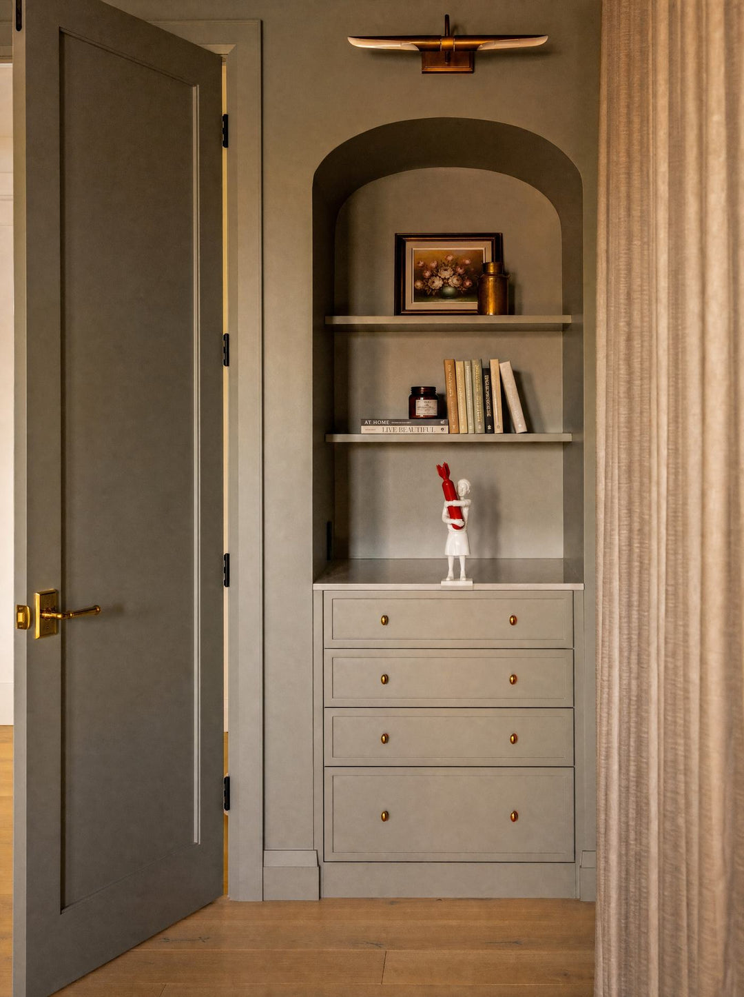 Disarm sculpture set in an olive green wall niche