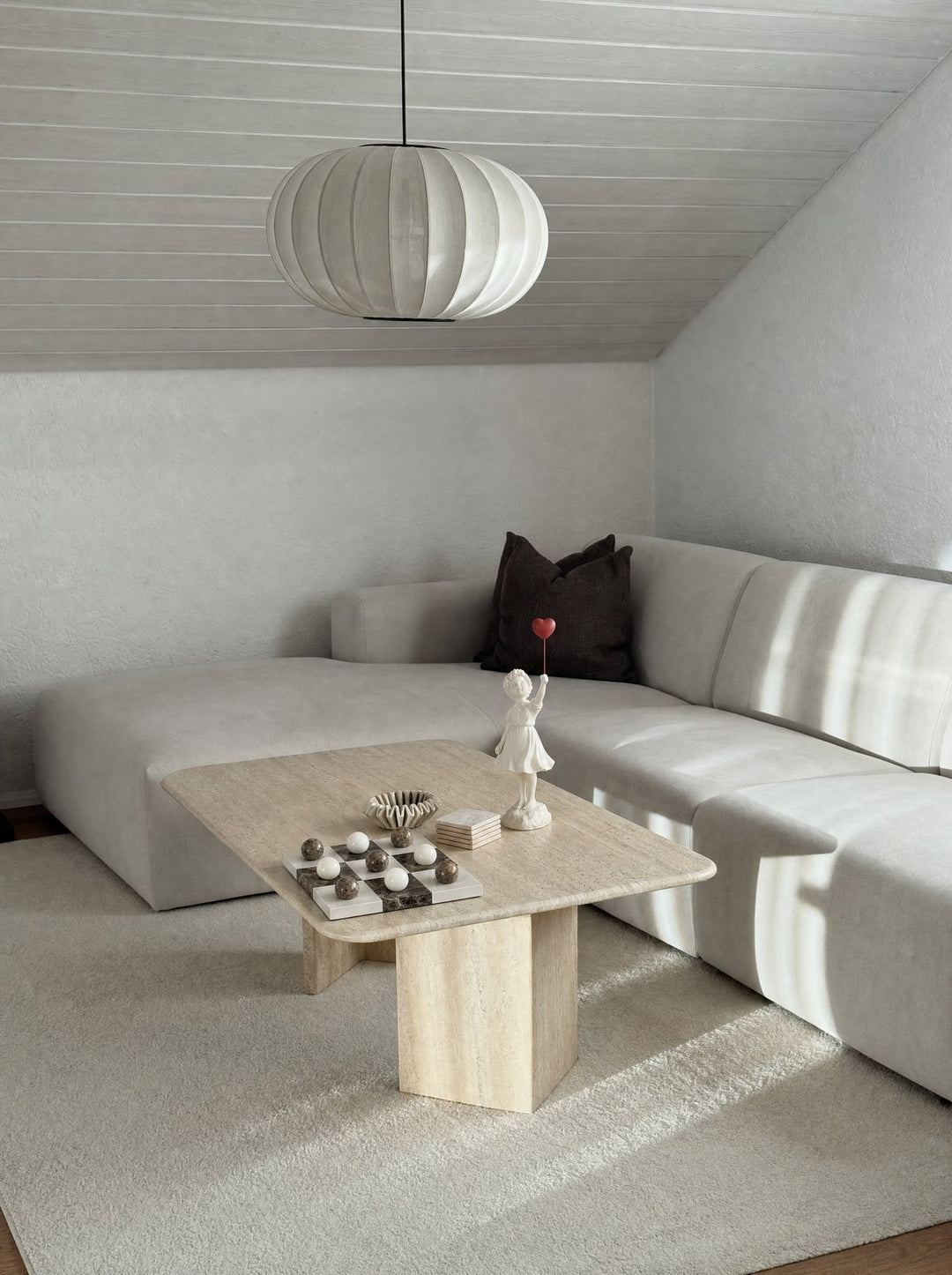 Ascend sculpture beside a Lapilli board on a travertine table in an attic room