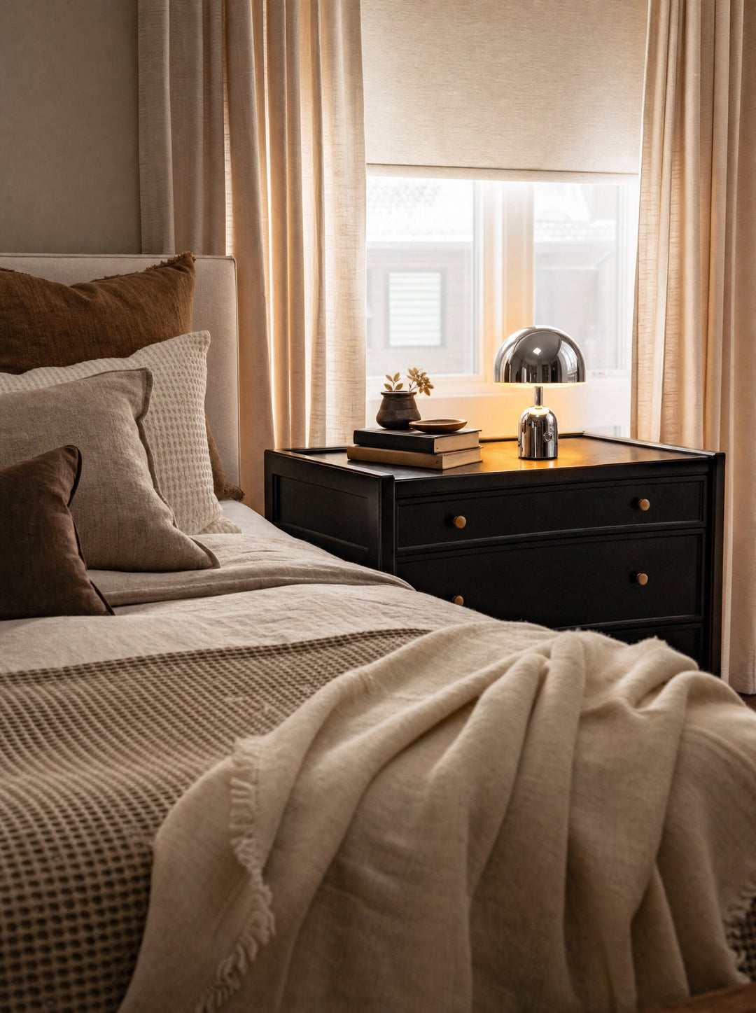 Vespers lamp lit on a bedroom nightstand
