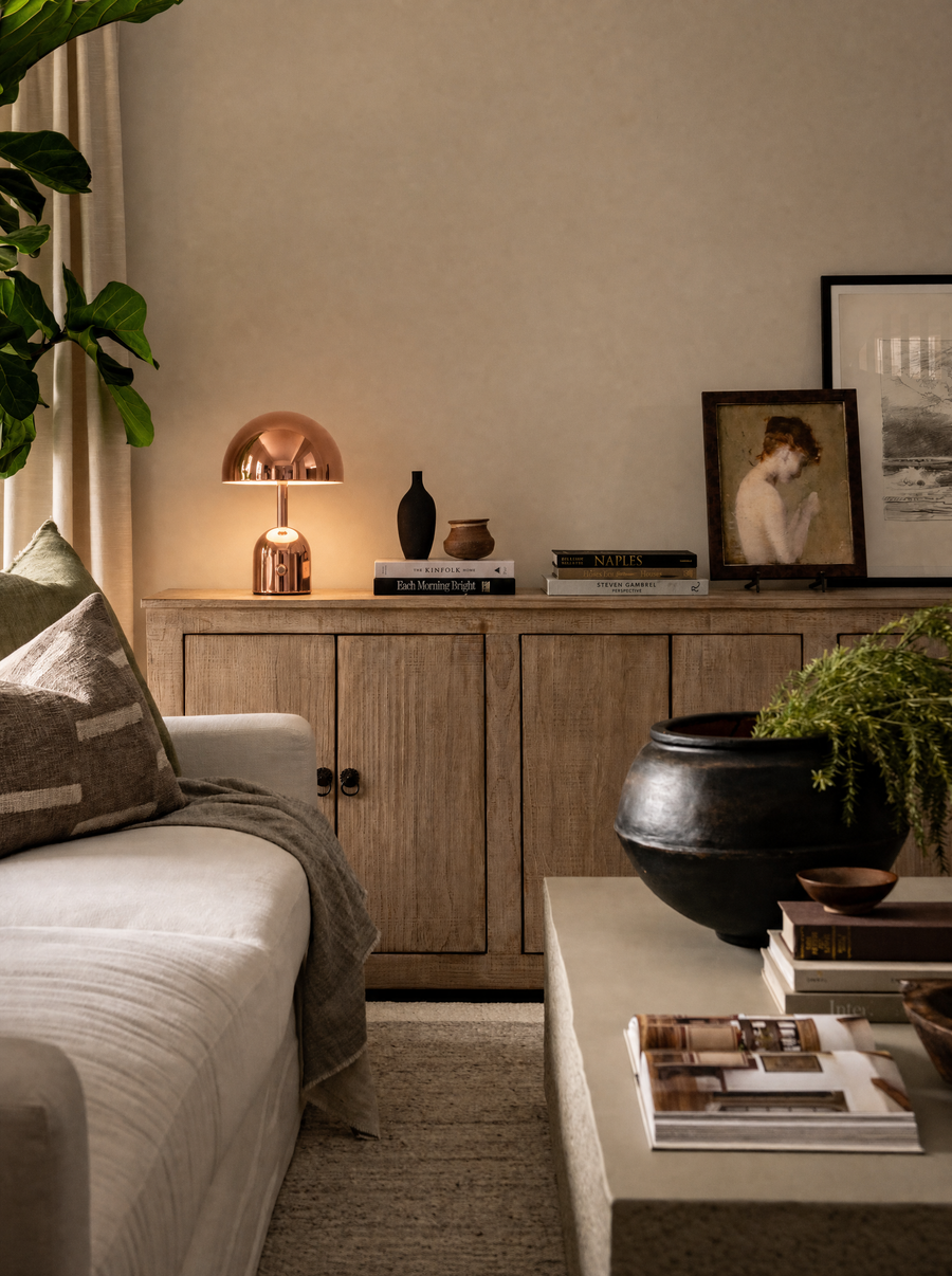 Vespers table lamp, rose gold finish, mirror-polished, in a living room setting.