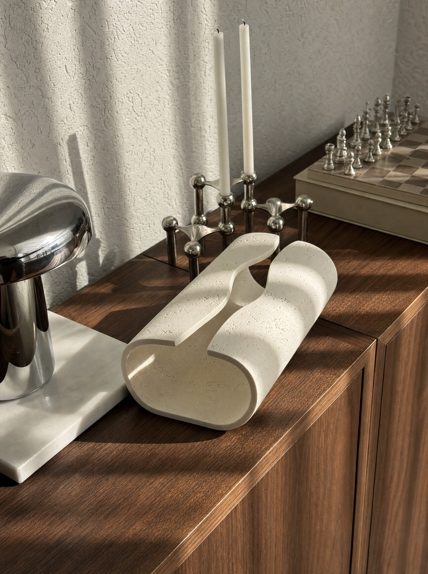 Volute ceramic tissue holder on a desk in ordinary daily use, soft afternoon light.